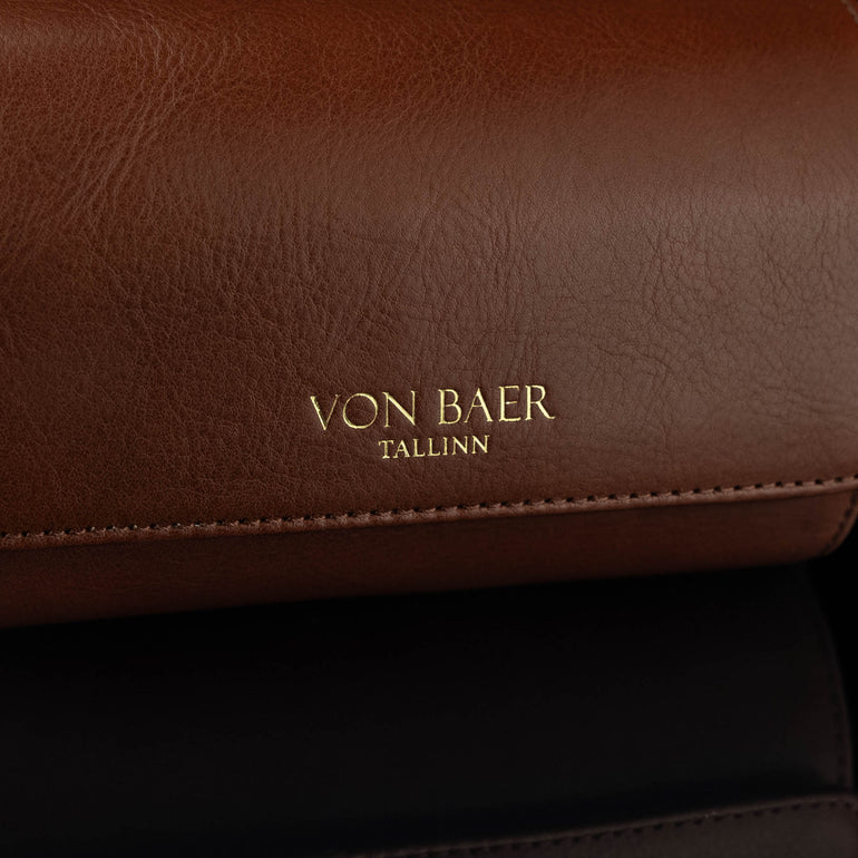 A close-up of the 'Von Baer Tallinn' logo on a brown luxury leather watch roll.