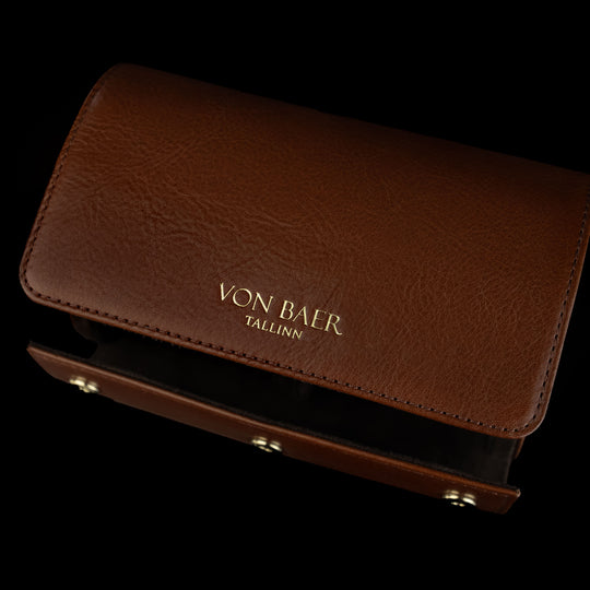 An upper view of a brown Von Baer luxury leather watch roll.