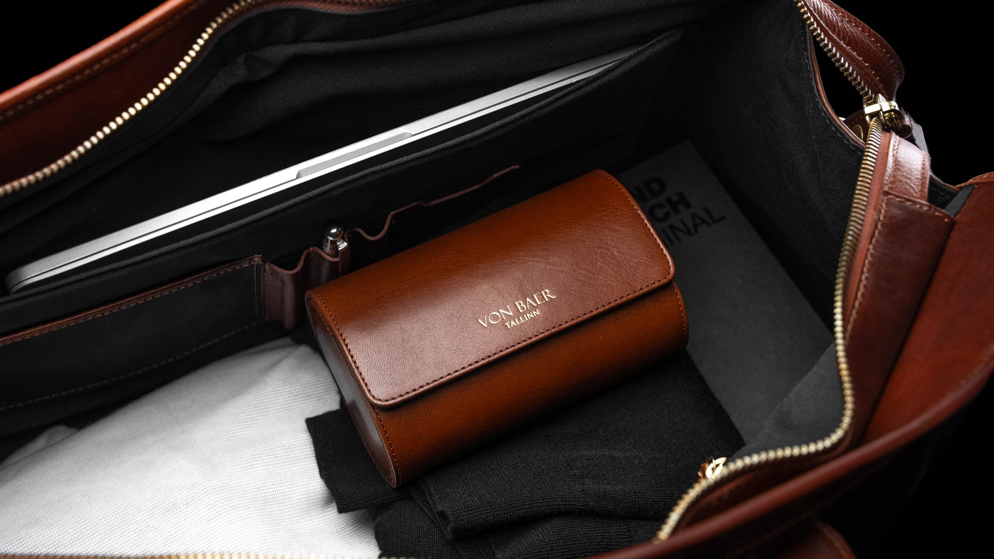A Von Baer luxury leather watch roll inside a weekender bag.