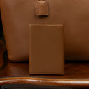 Luxury leather passport holder placed on a vintage wooden table