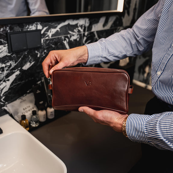 Von Baer man opens the superior leather wash bag in the luxury bathroom.