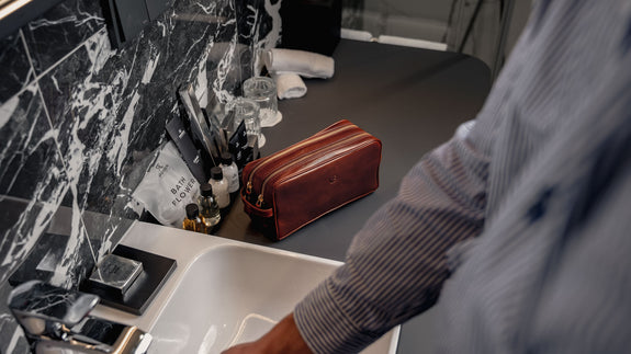 Von Baer man washing hands with the superior leather wash bag in the background – slider.