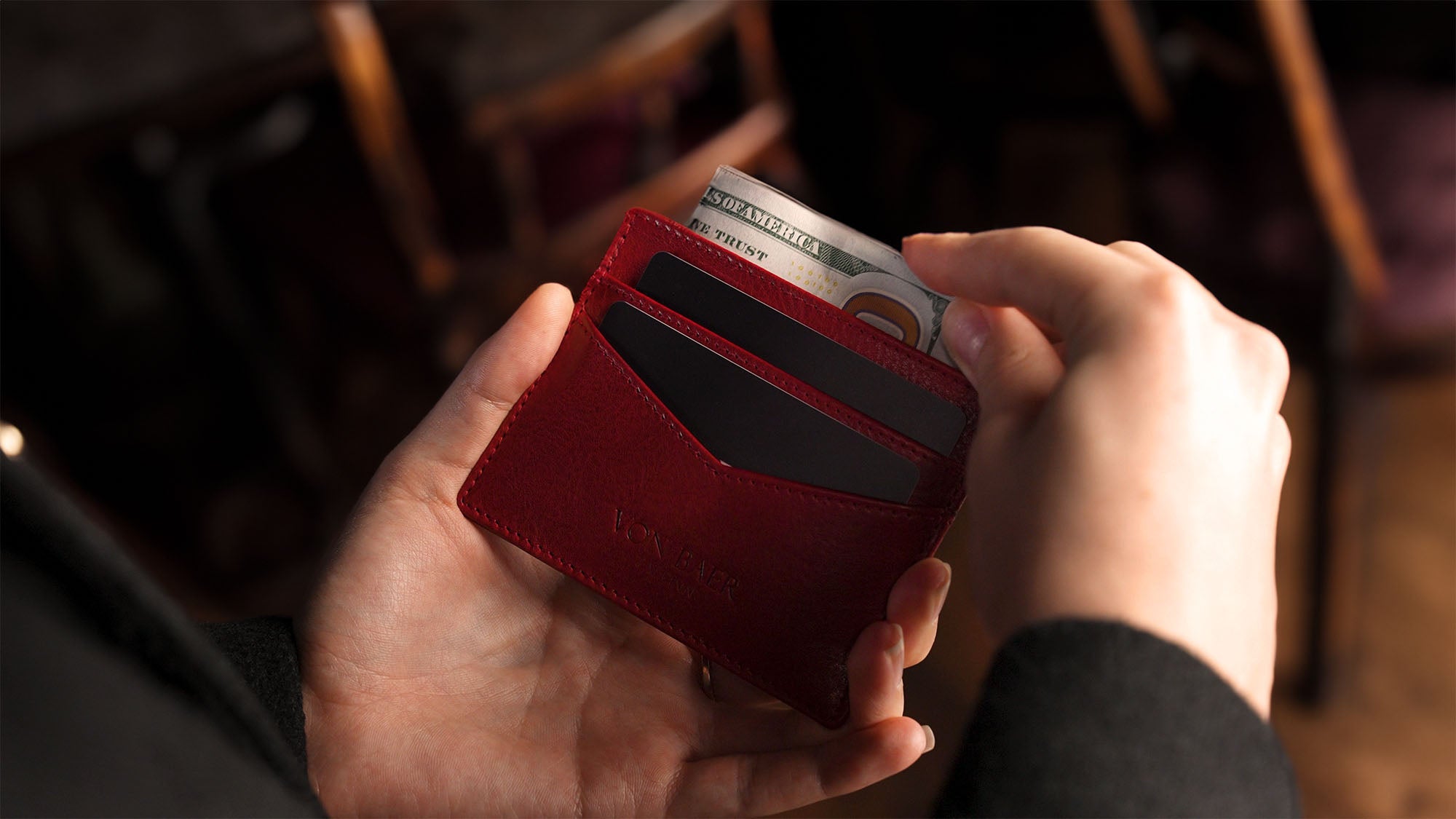 Man holding a long wallet in a meeting.