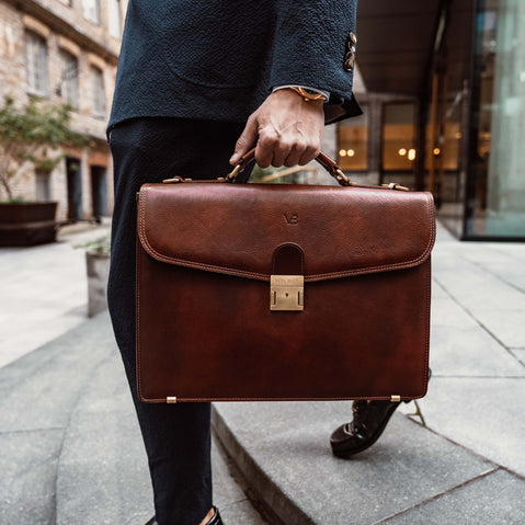 von baer no.1 leather briefcase in brown carried by the top handle by a male model