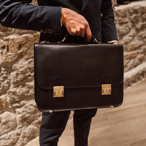 von baer no.2 italian leather messenger briefcase for work black in the hand of a man in a suit