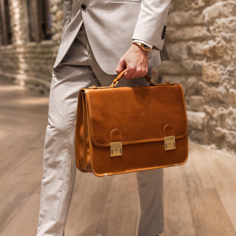 von baer no.2 luxurious leather messenger briefcase for work tan in the hand of a man in a suit