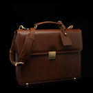 Compact full-grain leather laptop briefcase with shoulder strap and luggage tag for professional work, brown perspective view by Von Baer No.3.