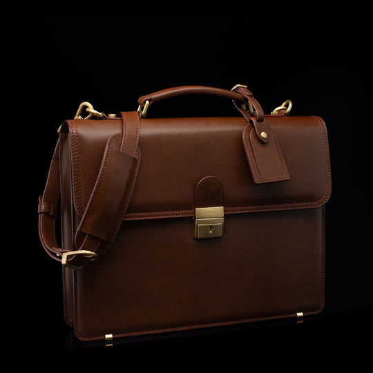 Compact full-grain leather laptop briefcase with shoulder strap and luggage tag for professional work, brown perspective view by Von Baer No.3.