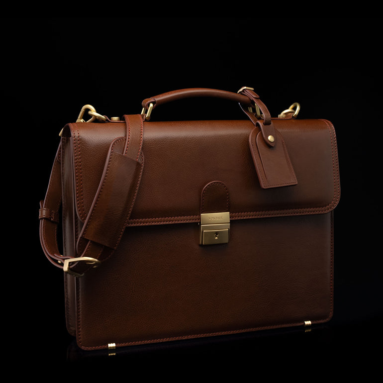 Compact full-grain leather laptop briefcase with shoulder strap and luggage tag for professional work, brown perspective view by Von Baer No.3.
