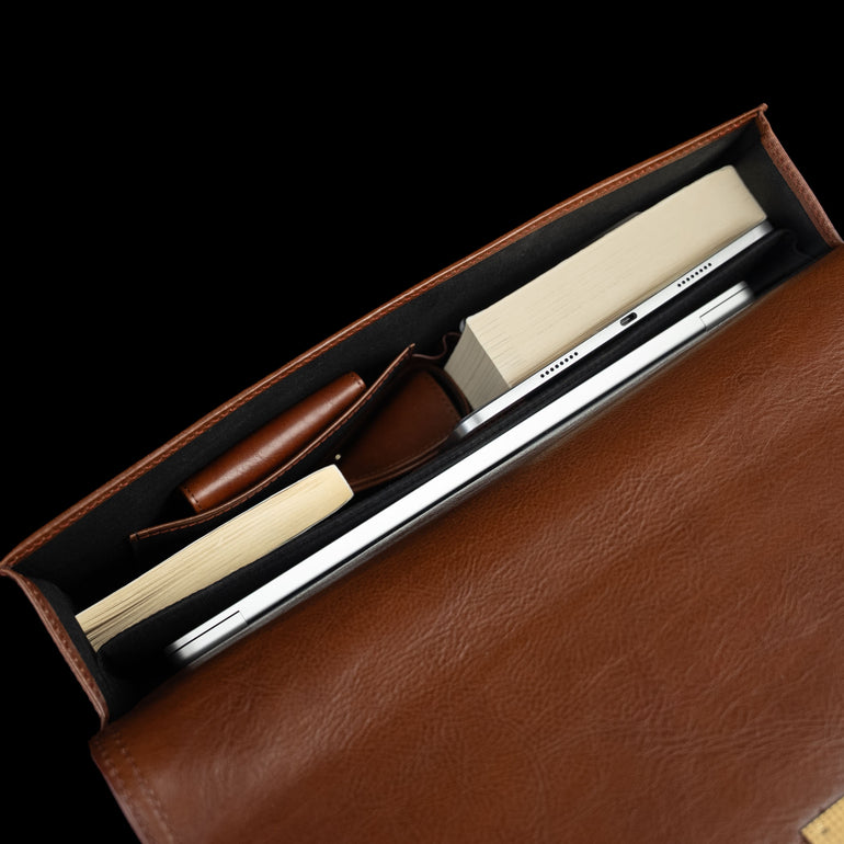 Slim full-grain leather briefcase interior top view with laptop, books, and accessories for professional work by Von Baer No.3.