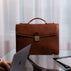 Large brown luxury men’s leather briefcase for work and documents in an office.