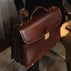 Large brown luxury men’s leather briefcase for work and documents on a table.
