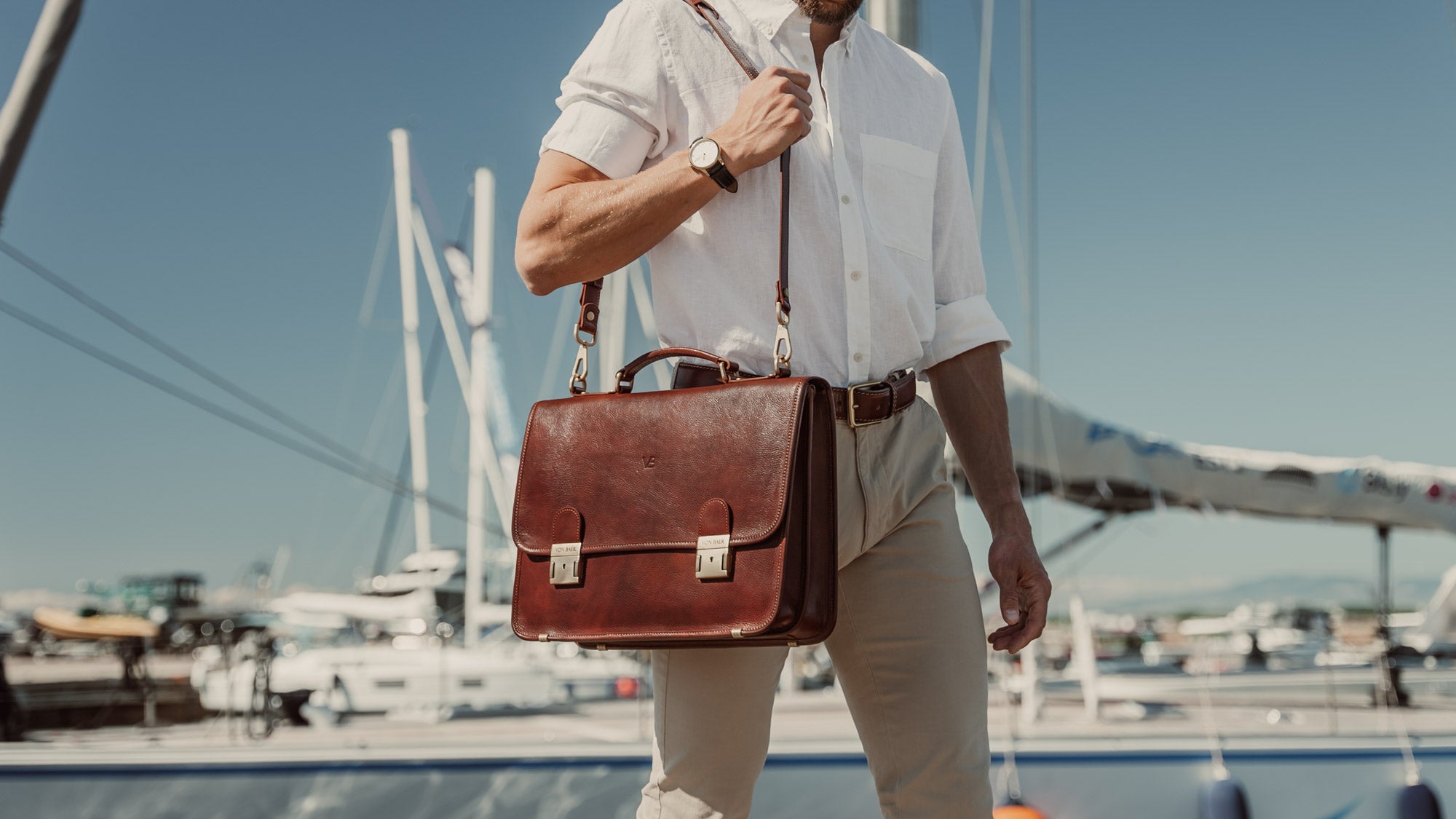 von baer no.2 luxury leather messenger briefcase brown with shoulder strap carried by businessman in harbour slider