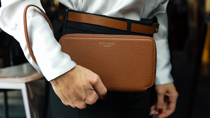 Von Baer origin luxury large leather purse with wrist strap held by a female model