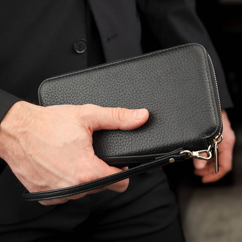 Von Baer origin luxury RFID men’s leather wallet in black held by a male model with wristlet, premium wallet for cards and cash.