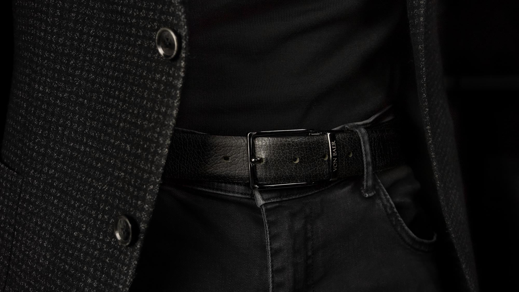 Von Baer Premier luxury reversible handmade premium leather belt for men, showcasing the black side, worn by a male model, with a close-up slider view.