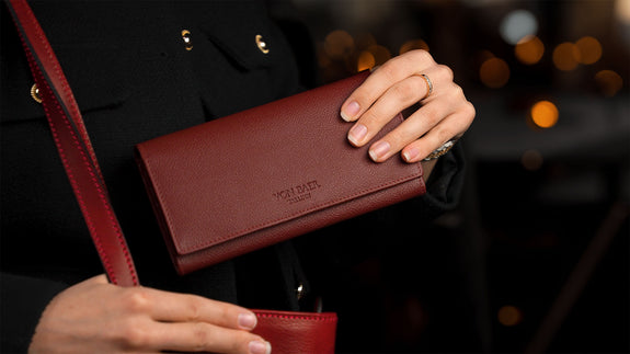 von baer quality leather womens purse red in the hands of female model in the cafe slider