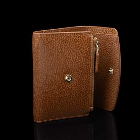 Von Baer Reverie elegant compact cognac pebbled leather wallet for women, shown open from the side against a black background, highlighting the side zipper and gold-tone hardware