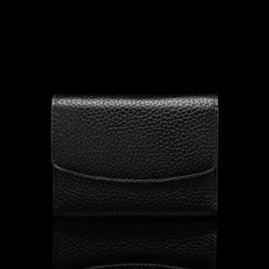 Von Baer Reverie small black pebbled leather wallet for women with an envelope-style flap, shown centered in a front view against a solid black background with a subtle reflection.