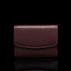 Von Baer Reverie compact burgundy pebbled leather wallet for women with a fold-over flap, shown centered in a front view against a solid black background with a subtle reflection.