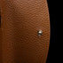 Von Baer Reverie small cognac pebbled leather wallet for women, shown in close-up highlighting the round metallic snap-button closure against a black background