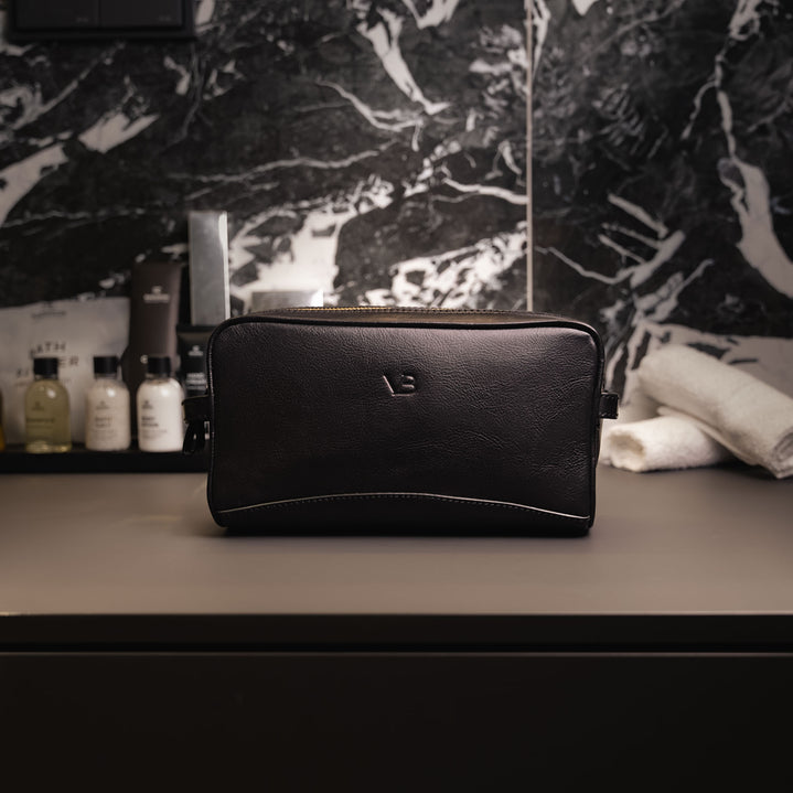 Von Baer superior high-quality luxury full-grain leather wash bag in black, placed in the elegant, expensive bathroom.