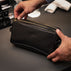 Von Baer superior high-quality luxury full-grain leather wash bag in black, held in the hands.