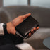 Von Baer Tallinn element leather card case in black held by a male model in a luxury hotel