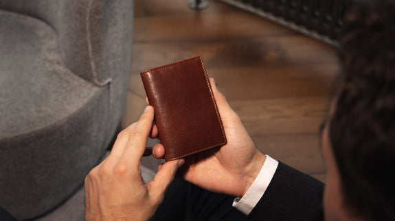 Von Baer Tallinn element leather card case in brown, held by a male model in a luxury hotel, slider