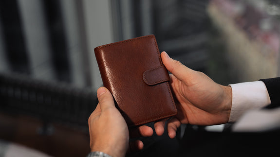 Von Baer Tallinn Heritage large men's high-quality leather trifold wallet held by a male model in luxury apartments, showcasing style and craftsmanship.