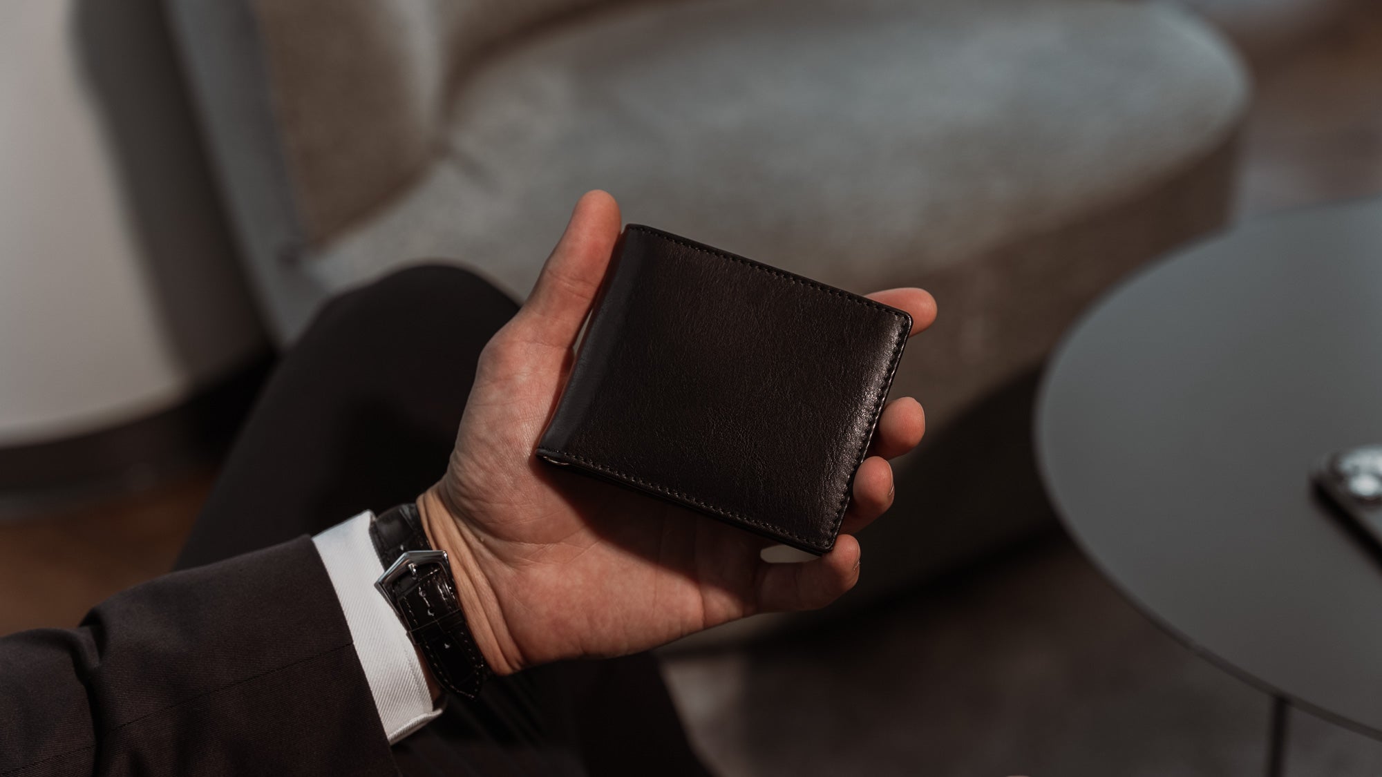 Von Baer Tallinn luxury high-quality Italian leather money clip wallet with RFID protection, held by a man, black color, slider view.