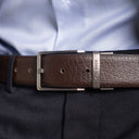 Von Baer Premier full-grain reversible brown leather 2-in-1 belt with silver buckle, worn by a man over a light blue shirt and dark pants