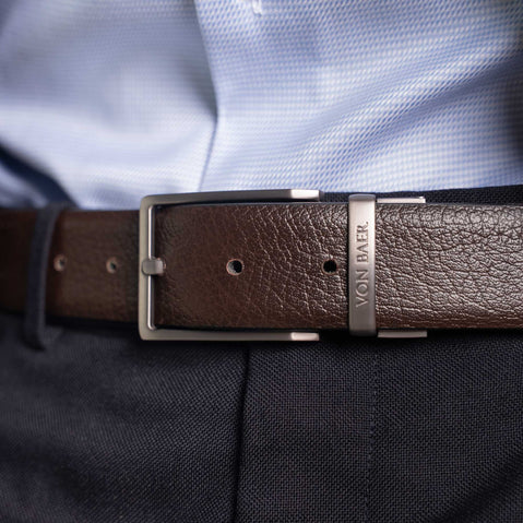 Von Baer Premier full-grain reversible brown leather 2-in-1 belt with silver buckle, worn by a man over a light blue shirt and dark pants