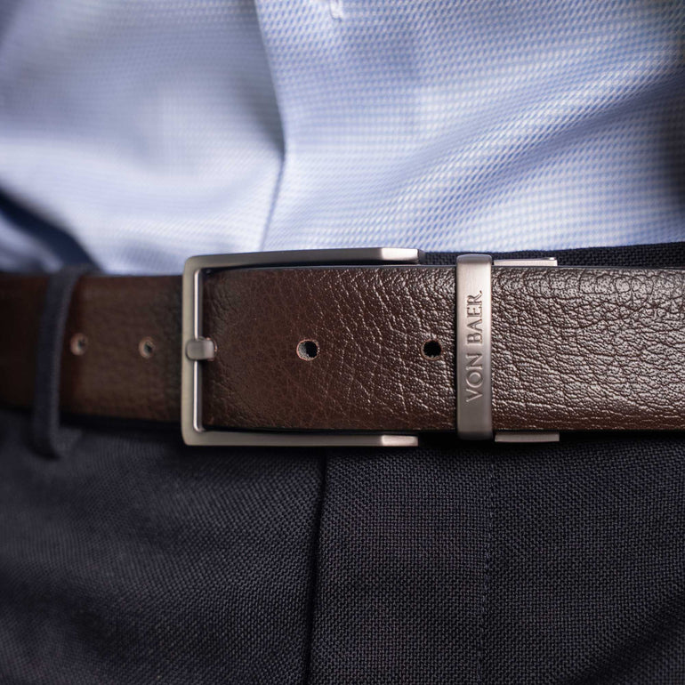 Von Baer Premier full-grain reversible brown leather 2-in-1 belt with silver buckle, worn by a man over a light blue shirt and dark pants
