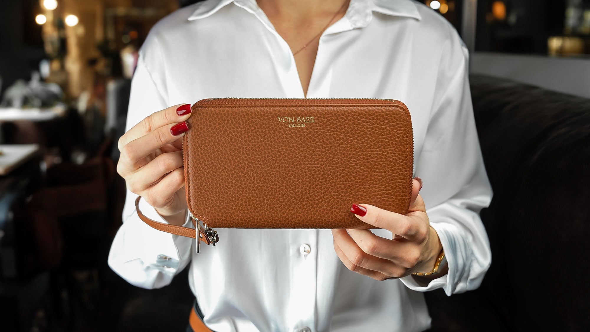 Von Baer W2 luxury large 2-in-1 leather purse held by a female model in a cafe