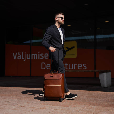 Von Baer Voyager luxury carry-on trolley bag in airport near departures entrance