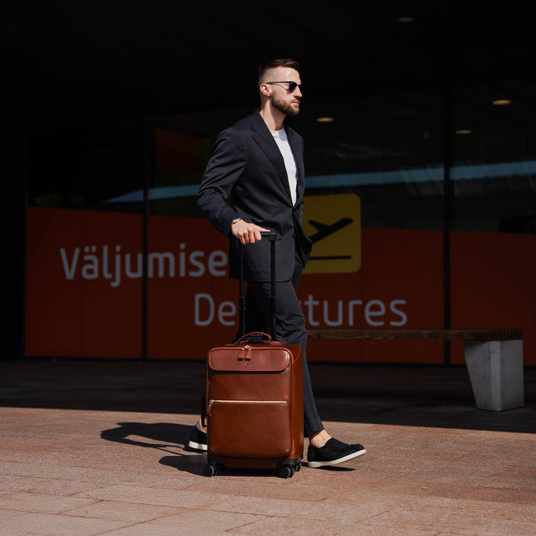 Von Baer Voyager luxury carry-on trolley bag in airport near departures entrance