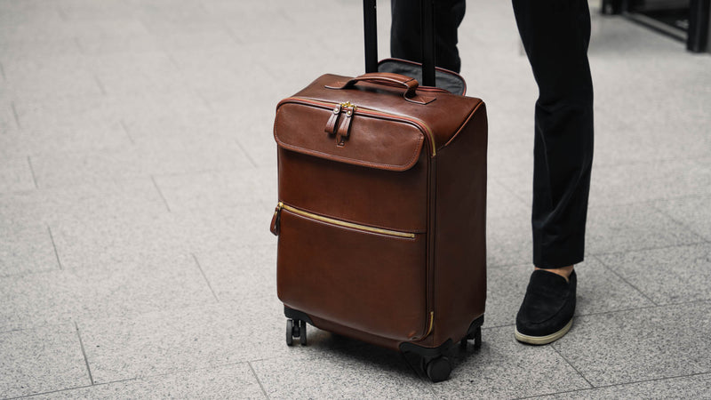 Von Baer Voyager luxury carry on trolley bag with male model in an airport
