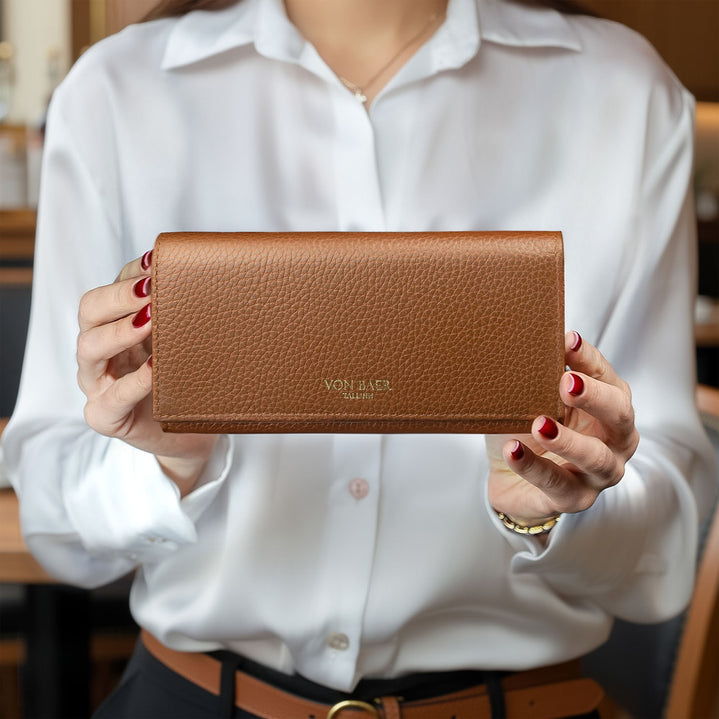Women Model holding a brown leather wallet with 'von baer' branding.