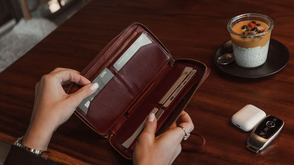 Von Baer W2 Large full-grain leather purse in red held by a woman in a coffee shop