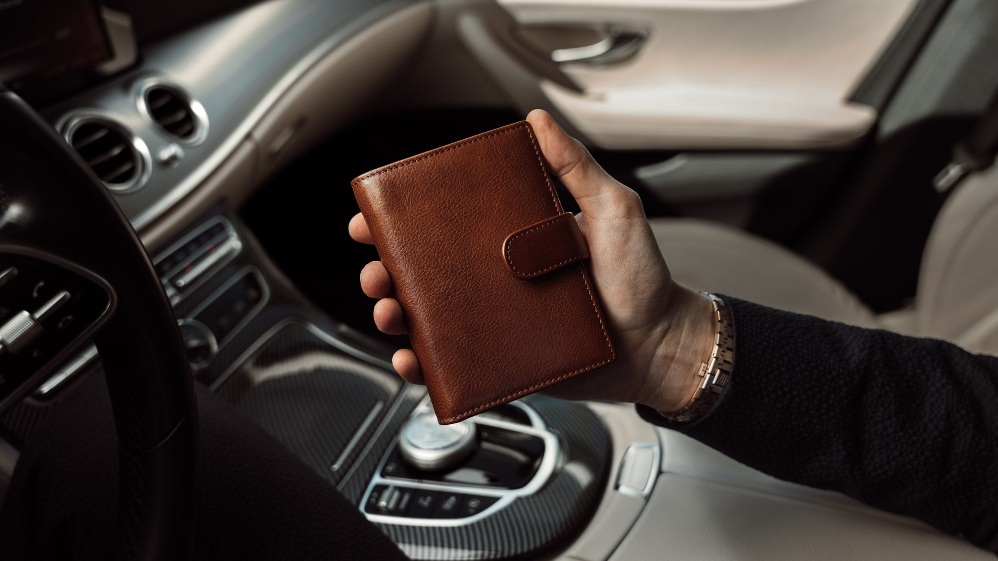 Von Baer Washington premium men's leather trifold wallet in solid brown, in the car, slider.