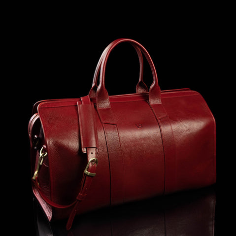 weekend bag deep red color with shoulder strap