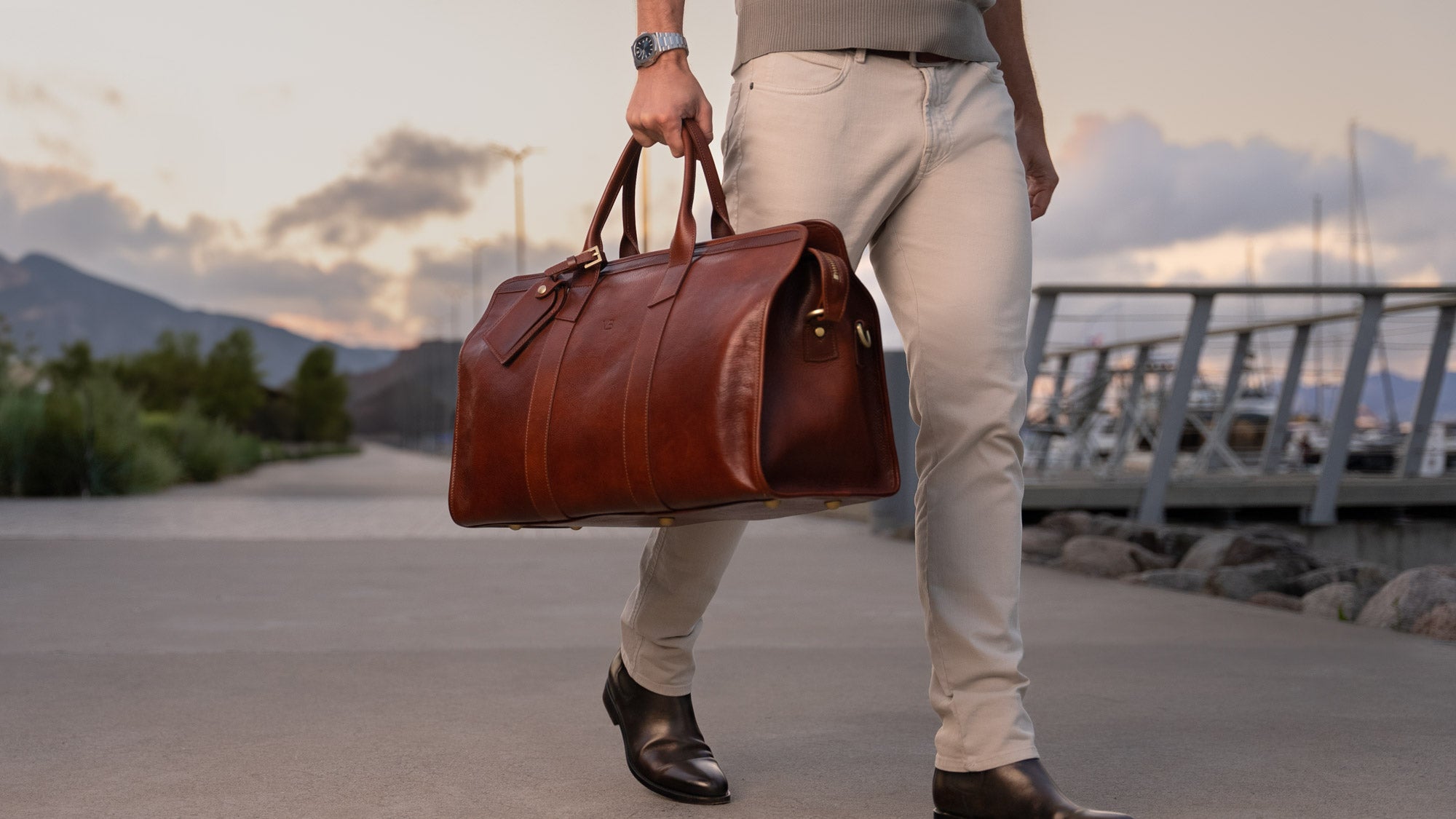 von baer weekender mens leather full grain weekend bag in hand of successful man at dock slider