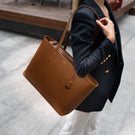 Von Baer Elegance leather tote bag in cognac tan, styled by a female model outdoors