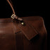 classic leather luggage tag solid brown back view attached to a travel bag