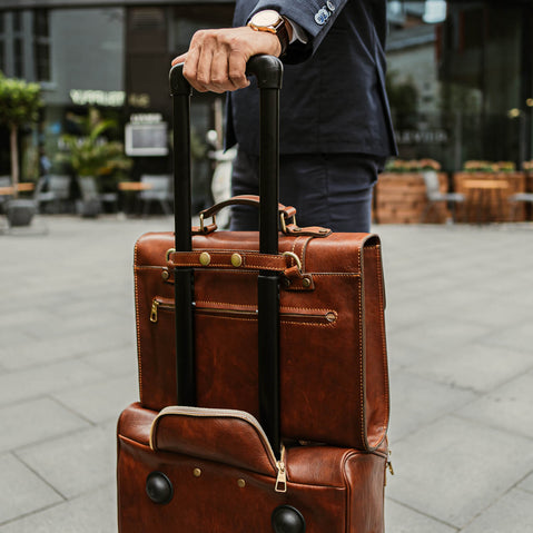 voyager leather carry on bag with wheels brown attached to a briefcase with trolley sleeve back view with a model