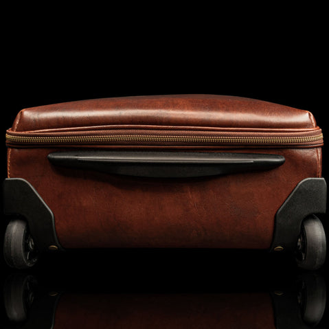 voyager leather carry on bag with wheels solid brown bottom side view with wheels visible