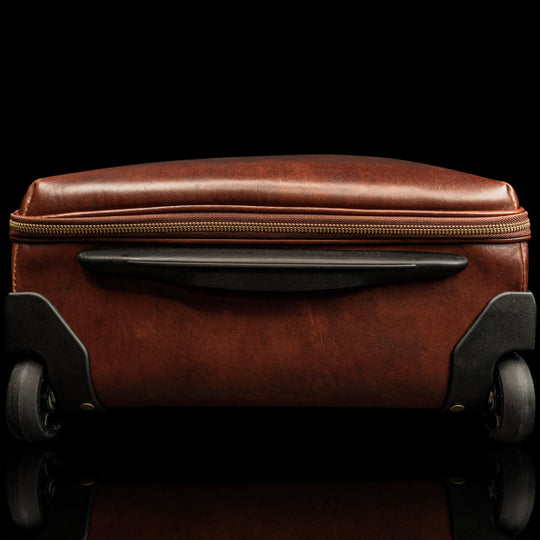 voyager leather carry on bag with wheels solid brown bottom side view with wheels visible 